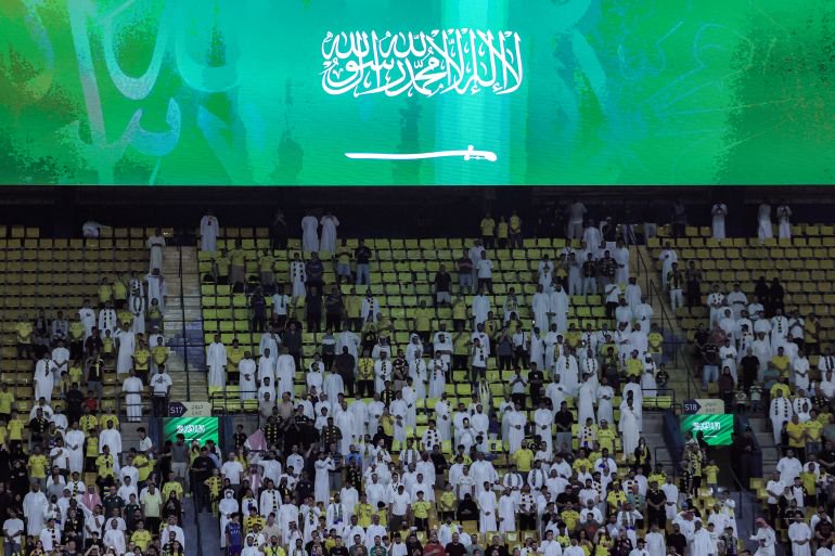 Football supporters stand up for the national anthem before the Saudi Pro League football match between Al-Nassr FC and Neom FC at Awwal Park in Riyadh on October 20, 2026. (Photo by Fayez NURELDINE / AFP)