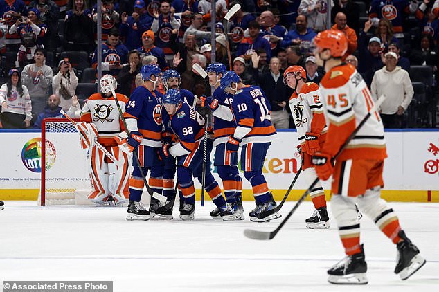 New York Islanders right wing Simon Holmstrom (92) is congratulated by teammates after scoring a goal past Anaheim Ducks goaltender Lukas Dostal during the first period of an NHL hockey game Tuesday, Oct. 20, 2026, in Elmont, N.Y. (AP Photo/Adam Hunger)