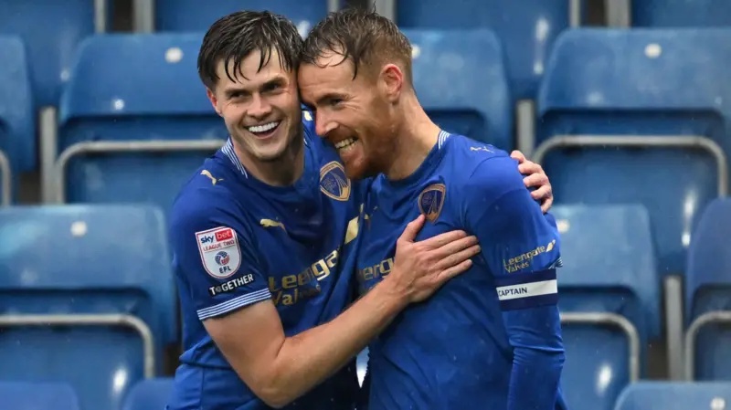 Tom Naylor and Tom Pearce celebrating a Chesterfield goal in their royal blue match shirts
