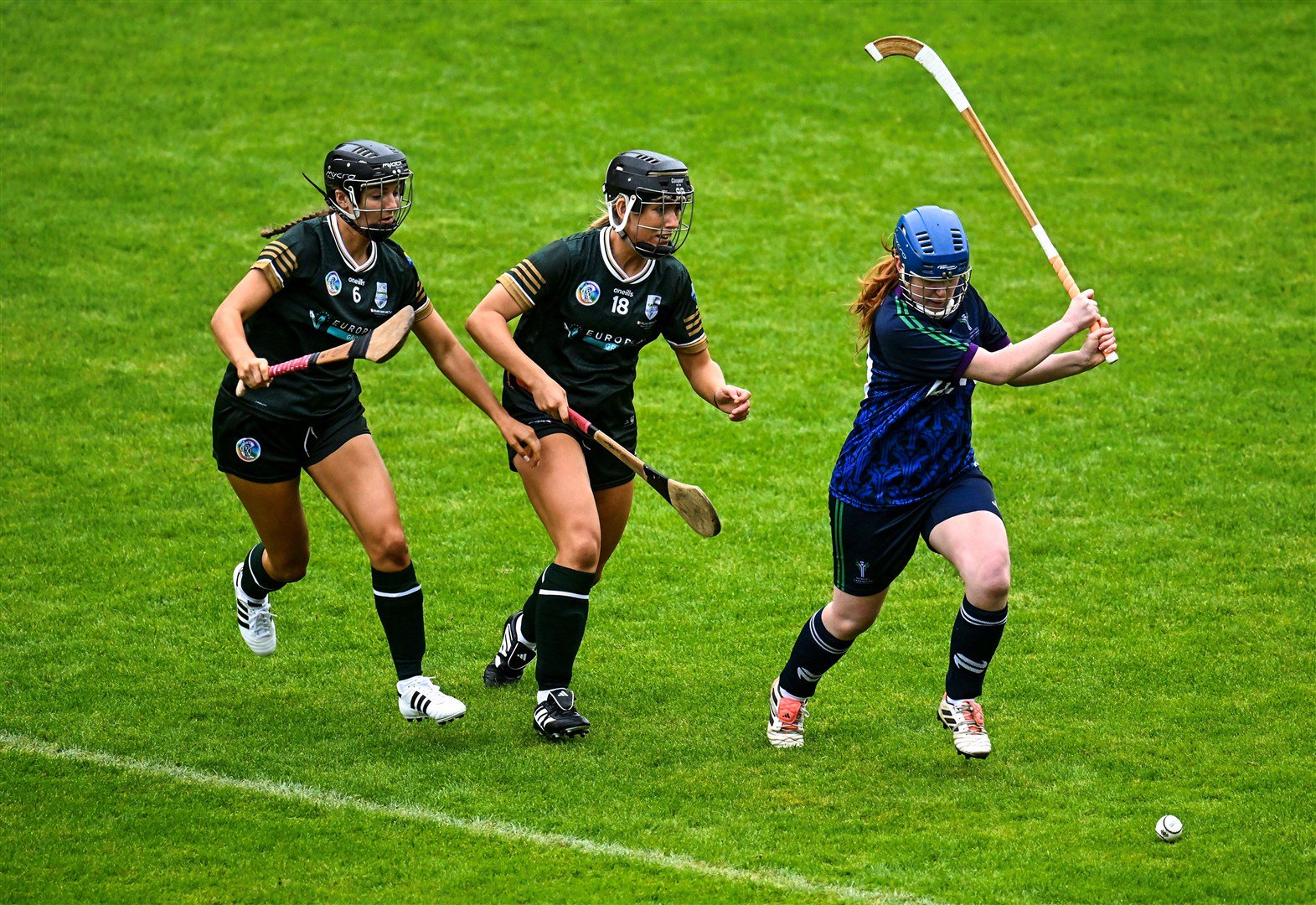 Badenoch's Rachel Borthwick gets the ball away ahead of the advancing Ava Fitzgerald (left) and Isobel Sheehan during the 2026 Camogie/Shinty International match. Picture: Piaras Ó Mídheach/Sportsfile.