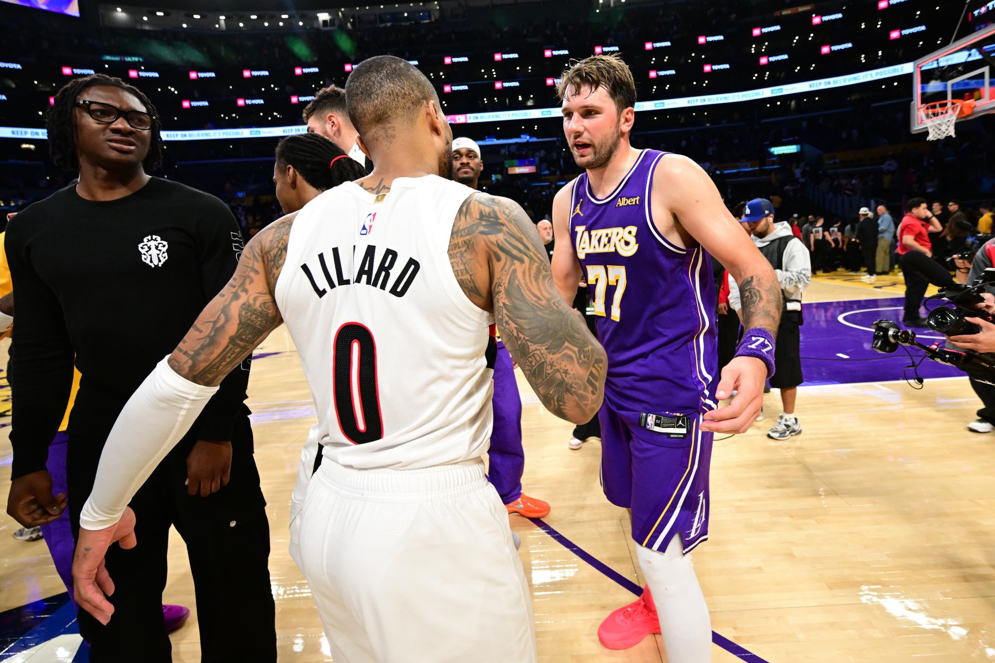 Damian Lillard of the Portland Trail Blazers and Luka Doncic of the Los Angeles Lakers interact after a game on the court.