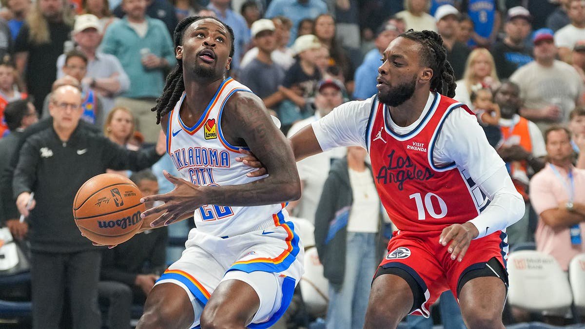 Cason Wallace drives past Darius Garland during an NBA game in Oklahoma City.