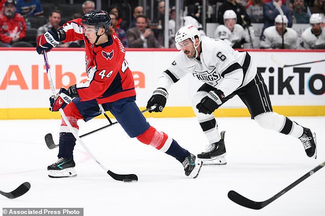 Washington Capitals defenseman Cole Hutson (44) shoots the puck against Los Angeles Kings defenseman Joel Edmundson (6) during the first period of an NHL hockey game, Tuesday, Oct. 20, 2026, in Washington. (AP Photo/Nick Wass)