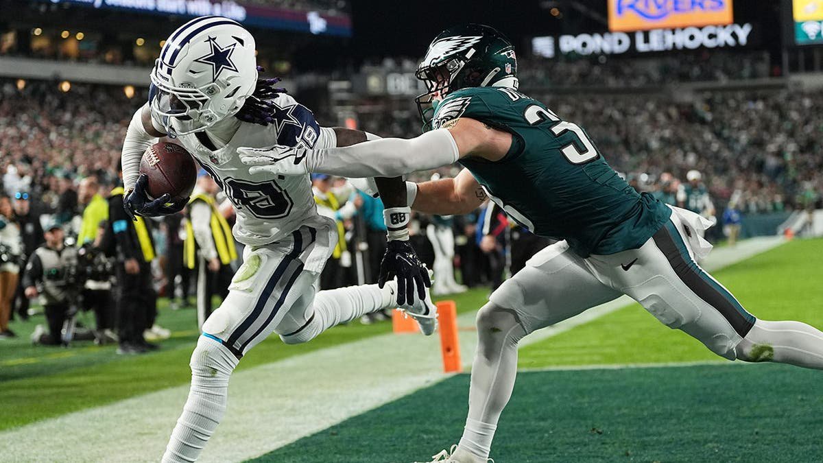 CeeDee Lamb catches a touchdown pass in front of Cooper DeJean during an NFL game.