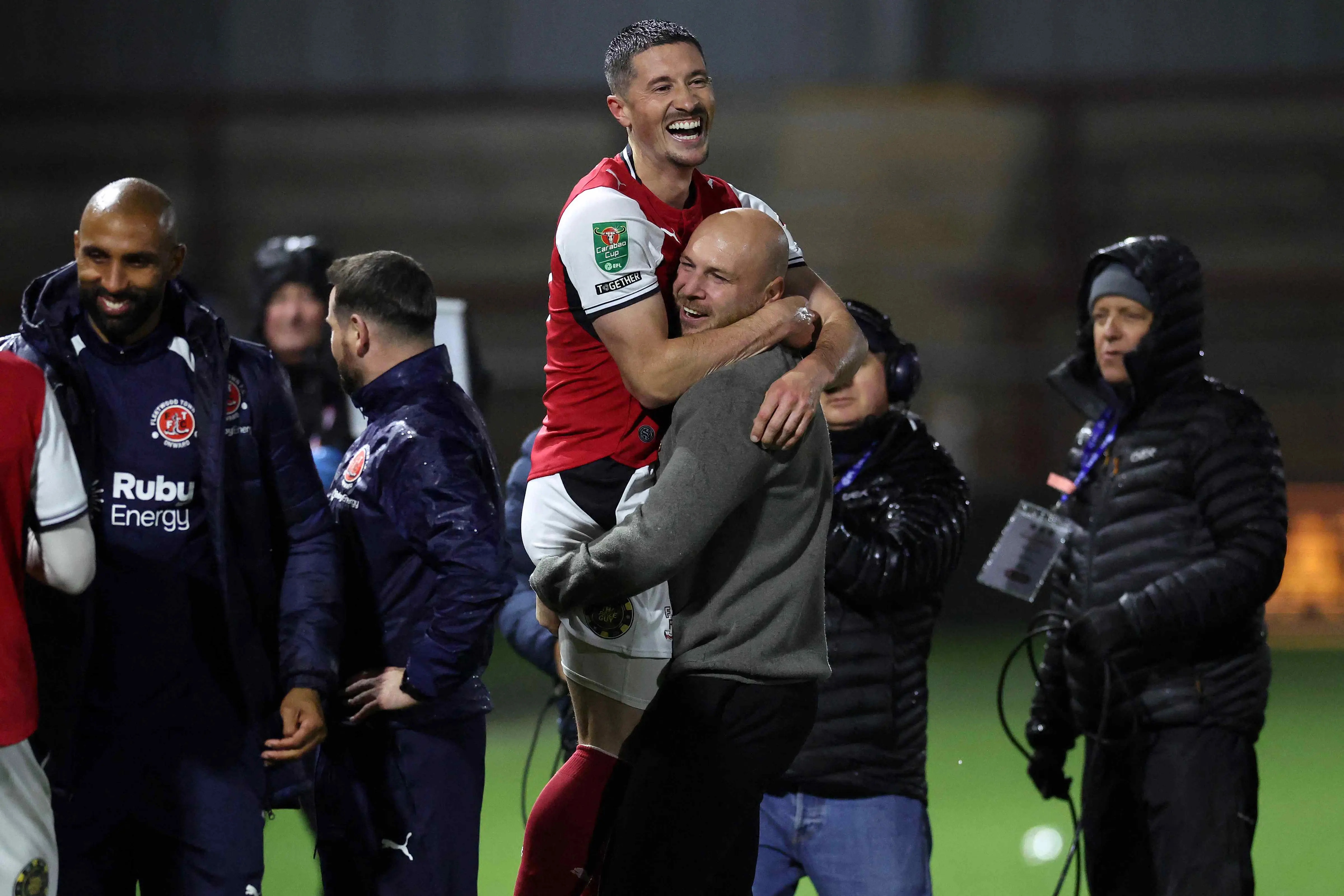 Fleetwood Town's Irish striker Ronan Coughlan (C) and Fleetwood Town's English manager Matt Lawlor celebrate winning the English League Cup fourth round football match between Fleetwood Town and Arsenal at Highbury Stadium in Fleetwood, north west England