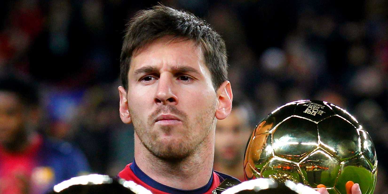 Lionel Messi poses with his three Ballon d'Or (Golden Ball) trophies