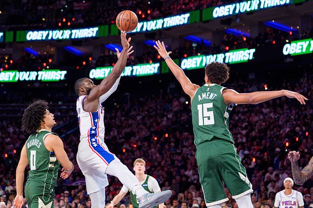 Philadelphia 76ers' Jaylen Brown, center, shoots the ball against Milwaukee Bucks' Nate Ament, right, during the first half of an NBA basketball game, Saturday, Oct. 24, 2026, in Philadelphia. (AP Photo/Chris Szagola)
