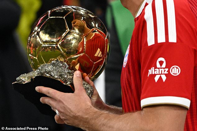 Bayern Munich's Harry Kane holds the Ballon d'Or trophy ahead of the German Bundesliga soccer match between Bayern Munich and Borussia Dortmund in Munich, Germany, Saturday, Oct. 31, 2026. (Sven Hoppe/dpa via AP)