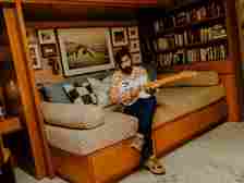 Image may contain Jason Schwartzman Couch Furniture Adult Person Clothing Footwear Shoe Art and Painting