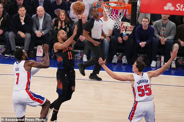 New York Knicks' Jalen Brunson (11) drives past Detroit Pistons' Paul Reed (7) and Duncan Robinson (55) during the first half of an NBA basketball game Tuesday, Oct. 27, 2026, in New York. (AP Photo/Frank Franklin II)