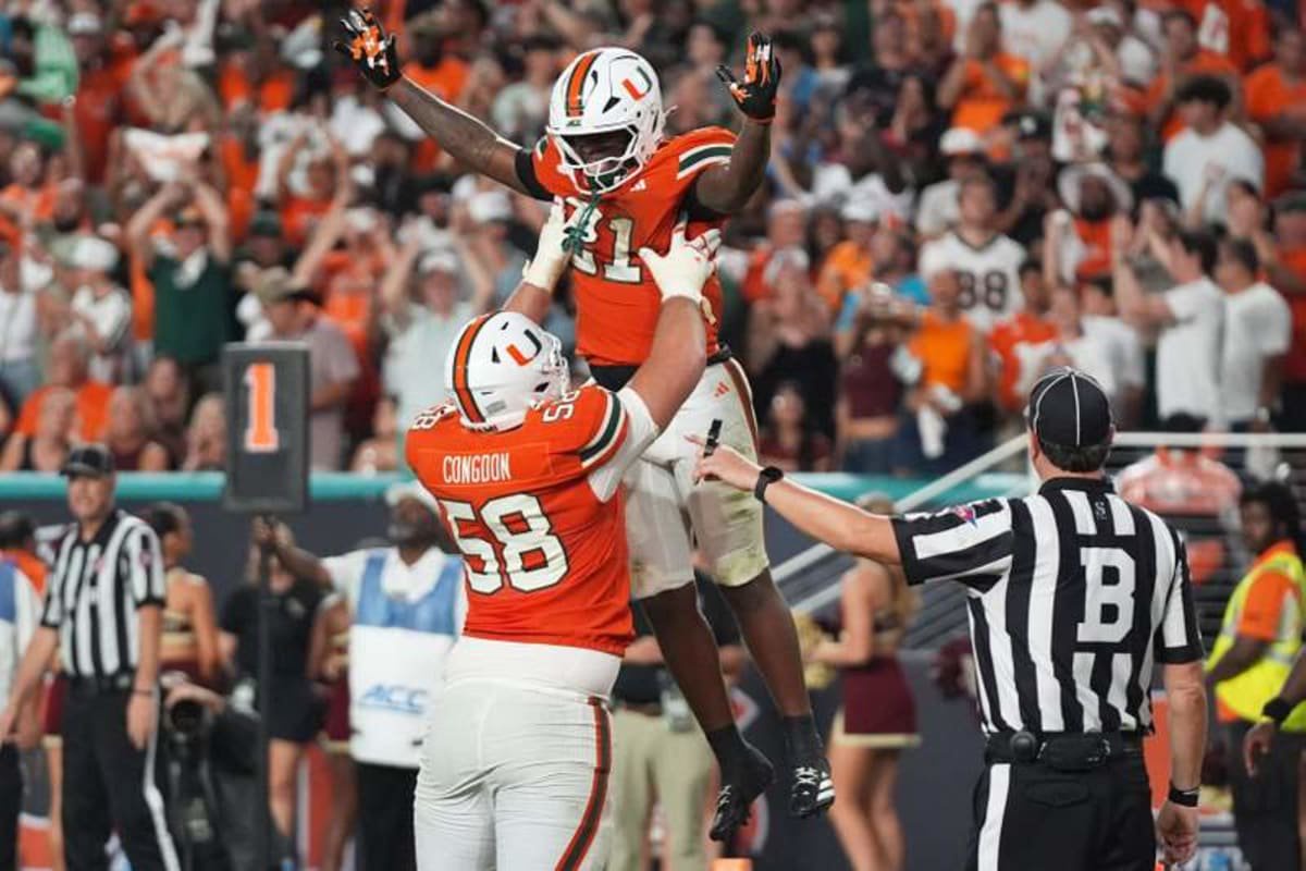 Miami running back Javian Mallory (21) celebrates with offensive lineman Ben Congdon (58) after scoring a touchdown during the second half of Saturday's win against Florida State in Miami Gardens. ©Lynne Sladky