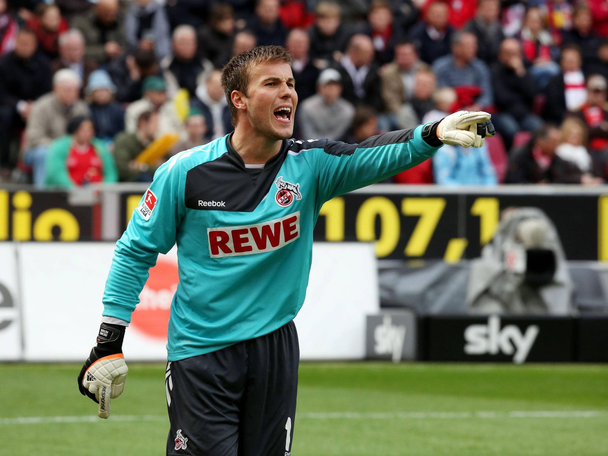 Michael Rensing, im FC-Trikot, schreit und zeigt mit dem Zeigefinger auf dem Platz.