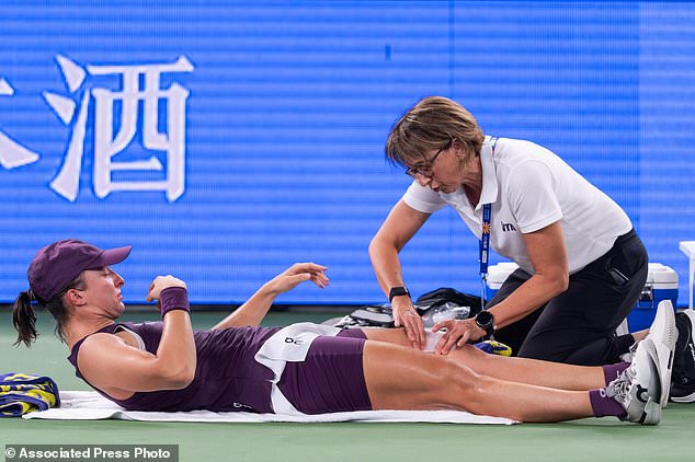 Iga Swiatek of Poland receives a medical timeout in a women's singles semifinal match against her compatriot Maja Chwalinska during the 2026 Wuhan Open tennis tournament in Wuhan in central China's Hubei Province on Saturday, Oct. 17, 2026. (Chinatopix Via AP)