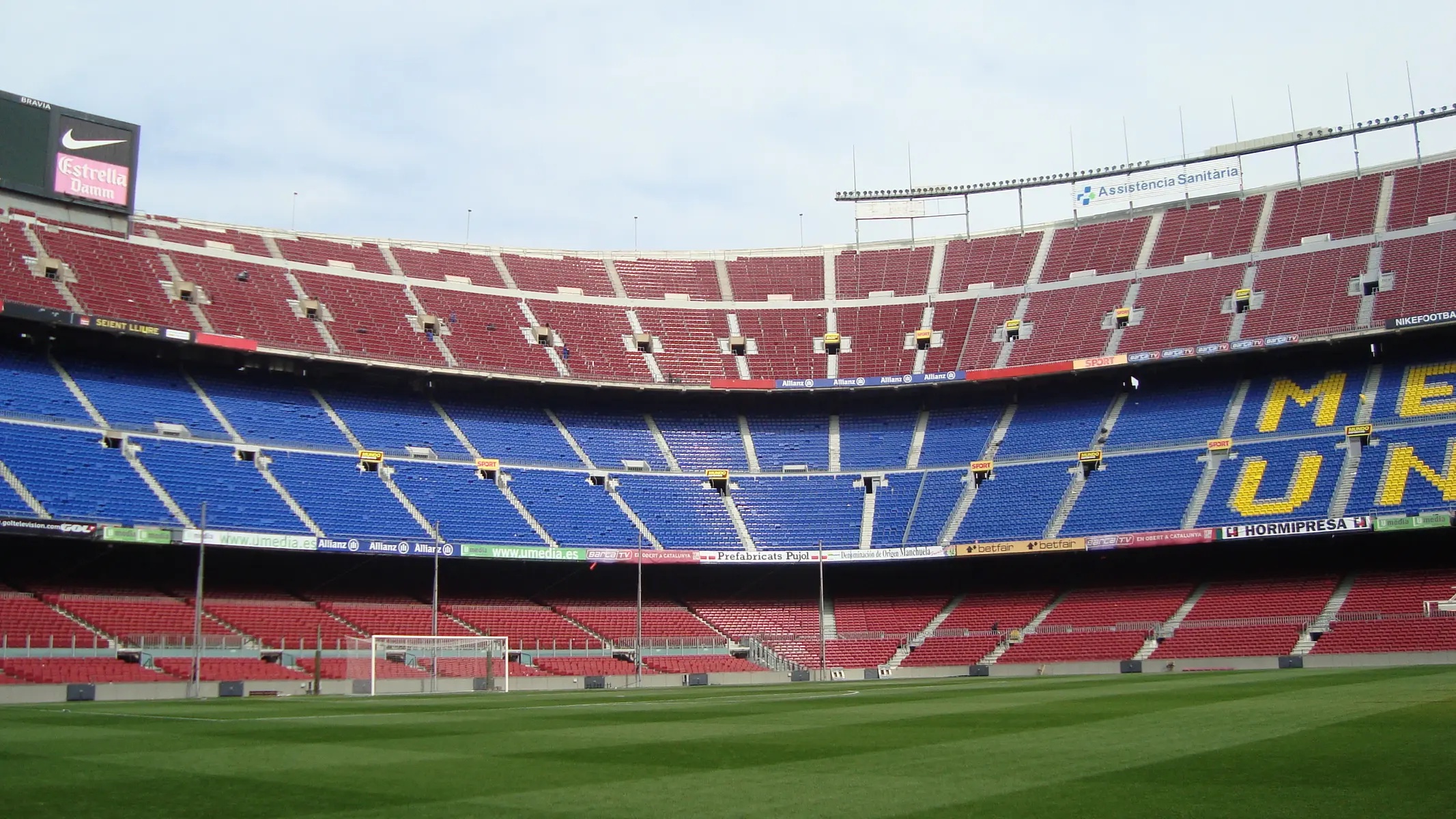 Wide view of the empty stands and green pitch of the Camp Nou stadium.
