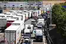 Vehicles queue to enter the Eurotunnel terminal at Folkestone in Kent on July 24, 2022