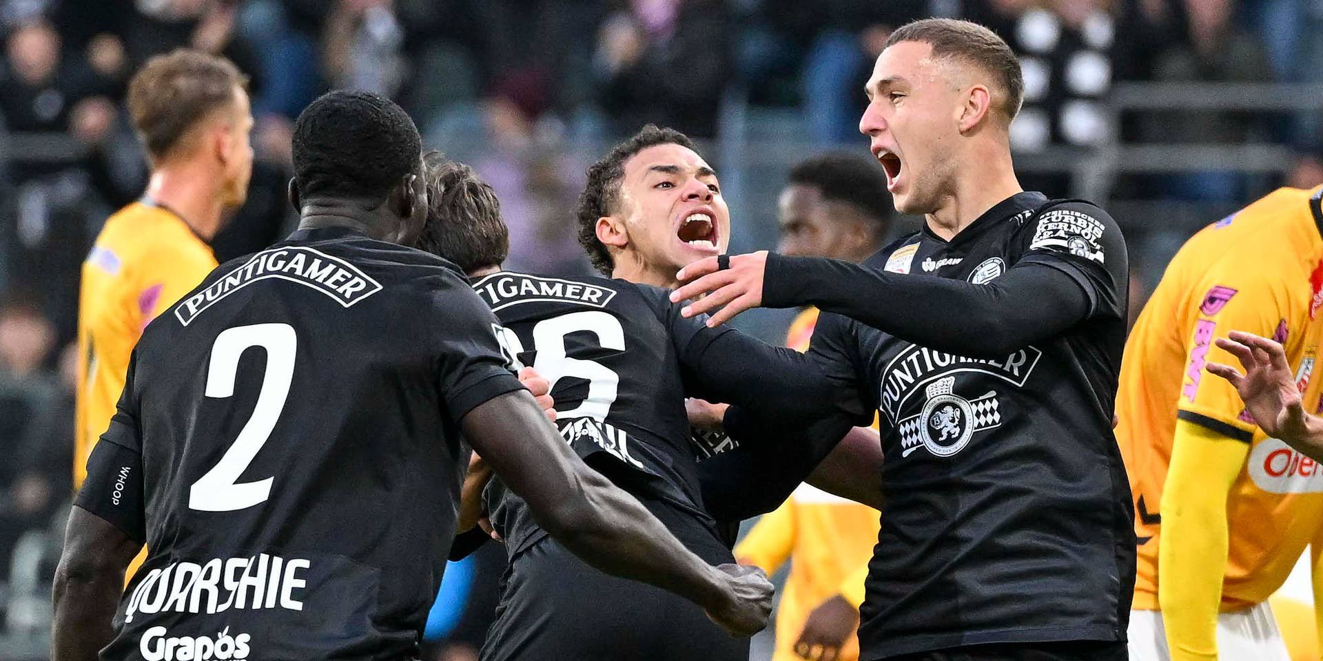 Fußballspieler von Sturm Graz jubeln nach einem Tor, andere Spieler im Hintergrund.