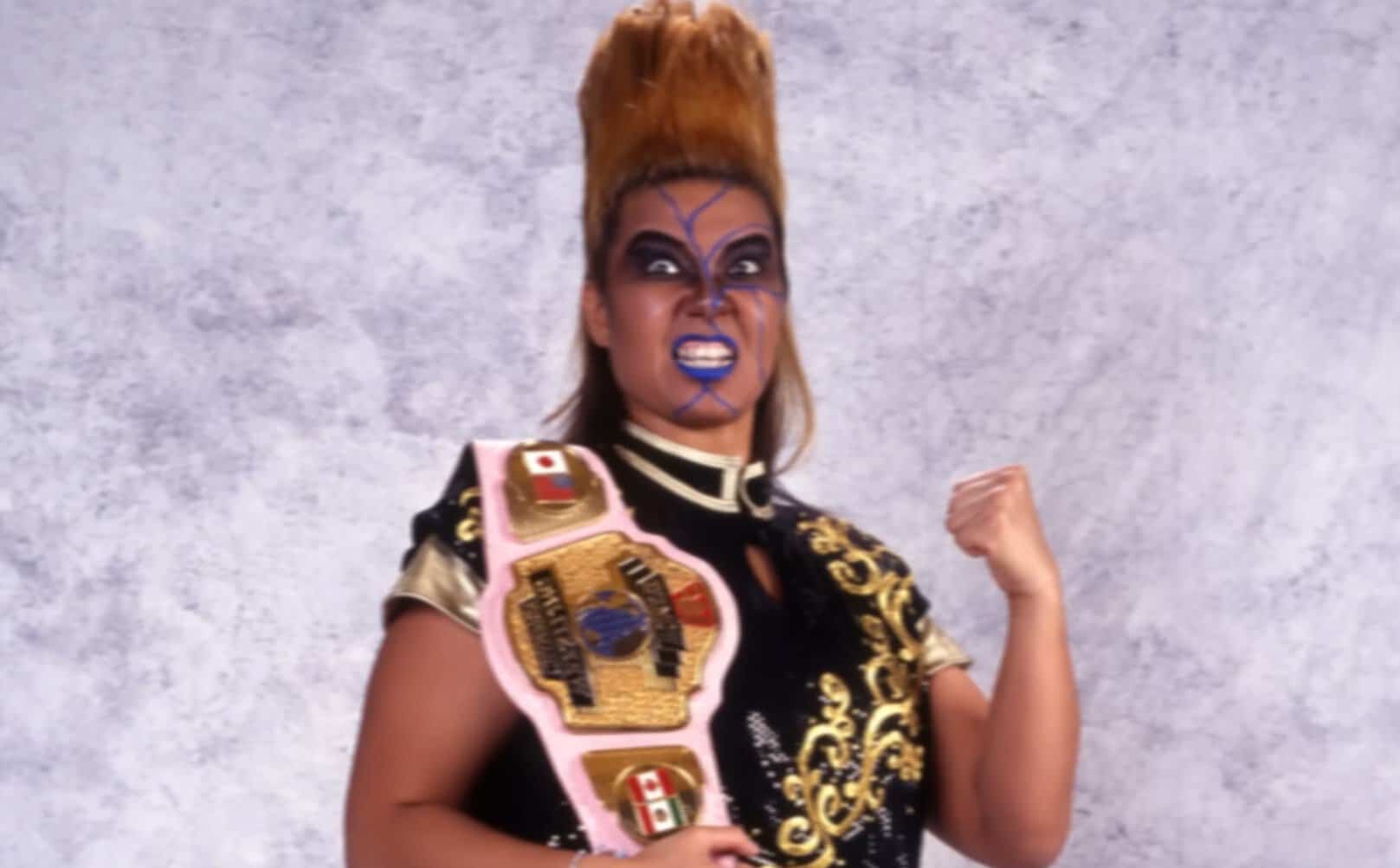 Bull Nakano in her face paint and tall hair, holding a championship belt