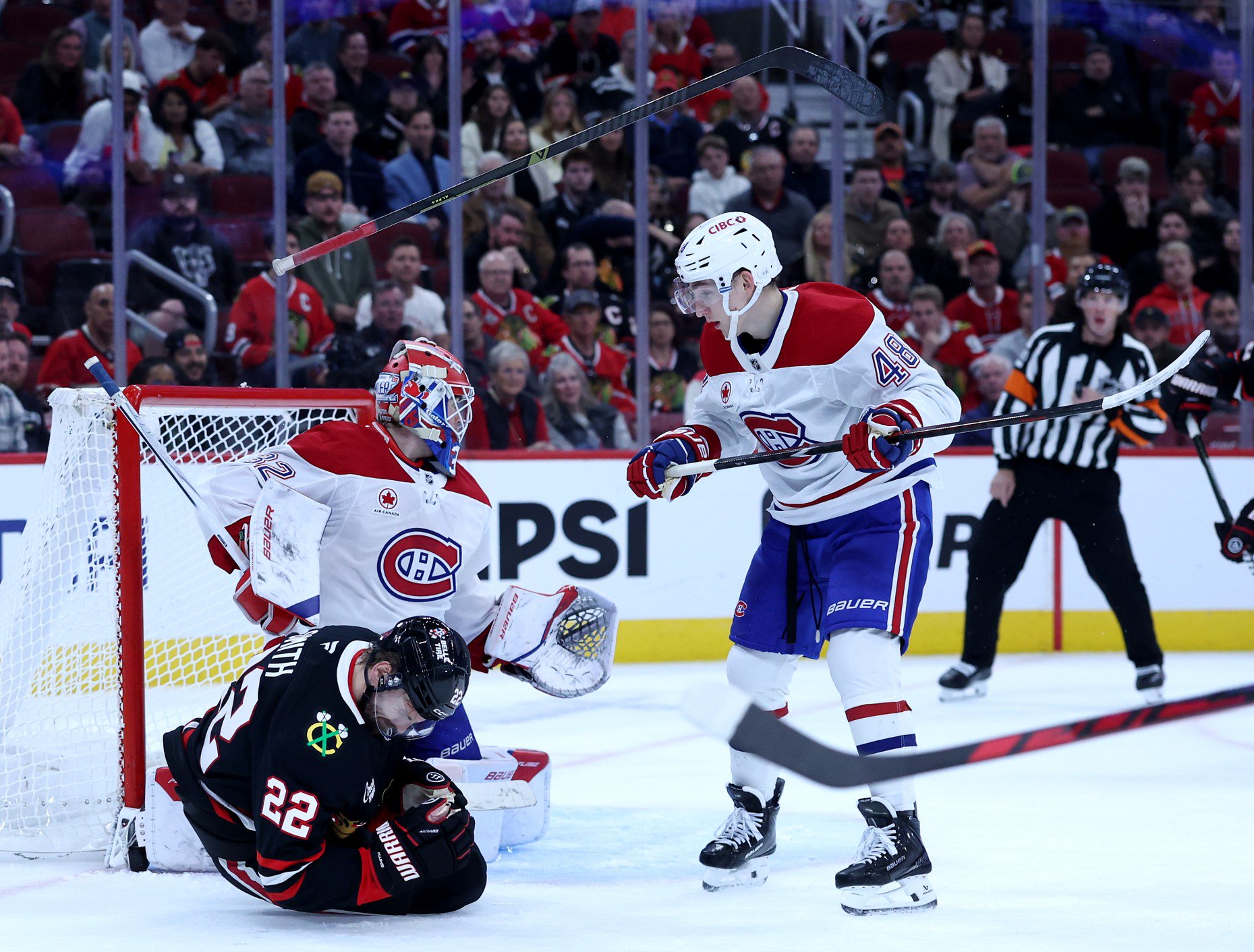 Chicago Blackhawks right wing Cole Smith (22) reacts after being hit in the face with a puck in the third period of a game against the Montréal Canadiens at the United Center in Chicago on Oct. 23, 2026. (Chris Sweda/Chicago Tribune)