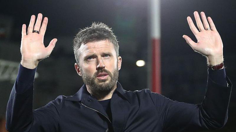 Manchester United head coach Michael Carrick holds his hands up to apologise to the away fans in Como