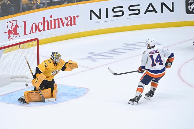 New York Islanders center Bo Horvat (14) scores on Nashville Predators goaltender Juuse Saros (74) during a shootout in an NHL hockey game Tuesday, Oct. 27, 2026, in Nashville, Tenn. (AP Photo/John Amis)