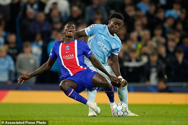 PSG's Nuno Mendes battles for the ball with Manchester City's Marc Guehi during the Champions League opening phase soccer match between Manchester City and Paris Saint-Germain in Manchester, England, Wednesday, Oct. 14, 2026. (AP Photo/Dave Thompson)