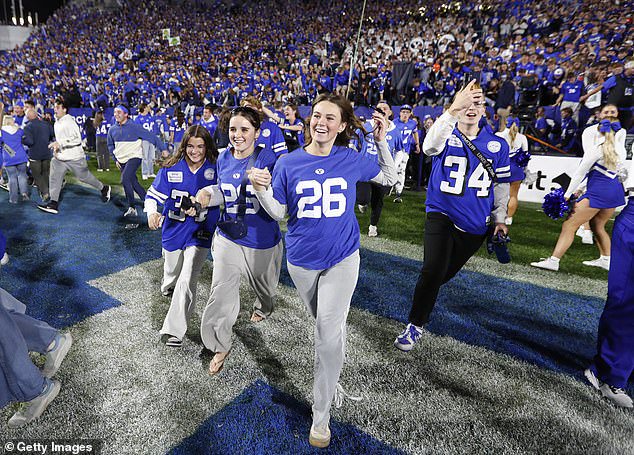 Students rush the field after the Brigham Young Cougars upset the Notre Dame Fighting Irish