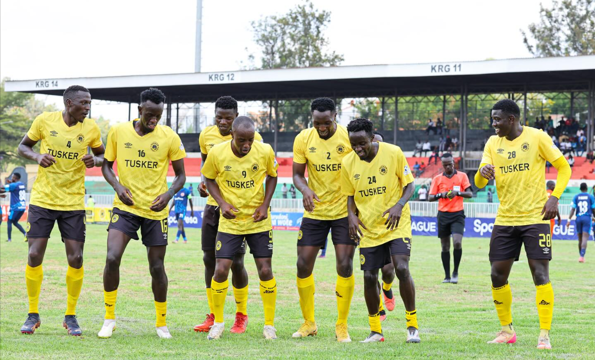 The Brewers players celebrate on the football pitch in front of stadium stands.