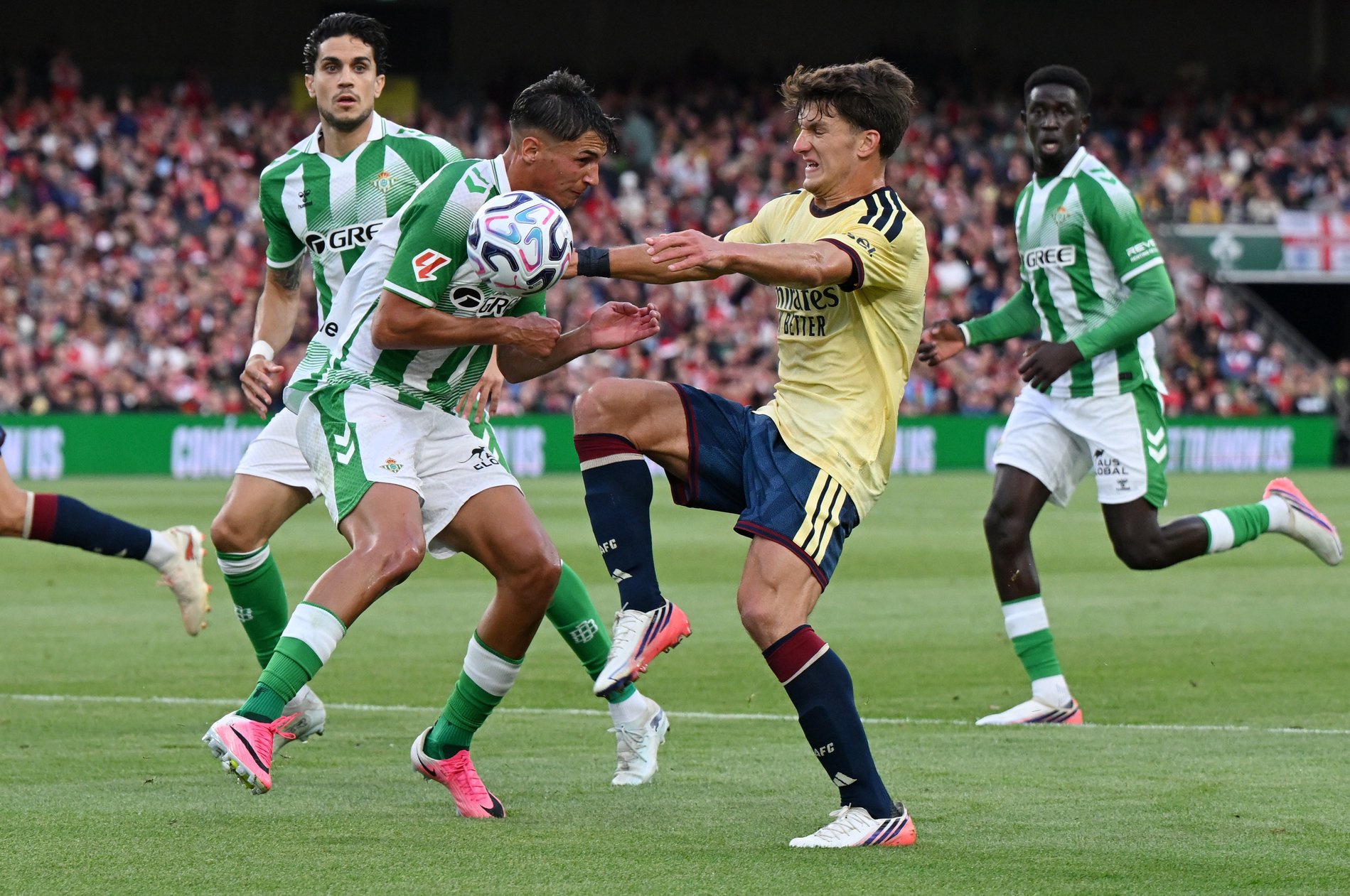 Facundo Bernal of Real Betis and Christos Tzolis of Arsenal FC challenge for the ball.