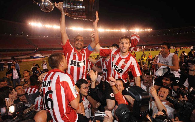 Bruno Henrique (esq.) e Carrillo, capitães de Flamengo e Estudiantes, respectivamente