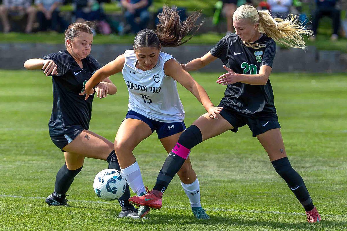 Richland senior Lauren Lindley (20), right, and junior Emily Gaudreault (26), left, battle Gonzaga Prep junior Jazlyn Arredondo (15) for possession during a non-league girls soccer match Saturday, Sept. 5, 2026, at Richland High School. Coach Mike Pardini identified Lindley as one of the Bombers’ key returning players and described her as a creative presence for Richland