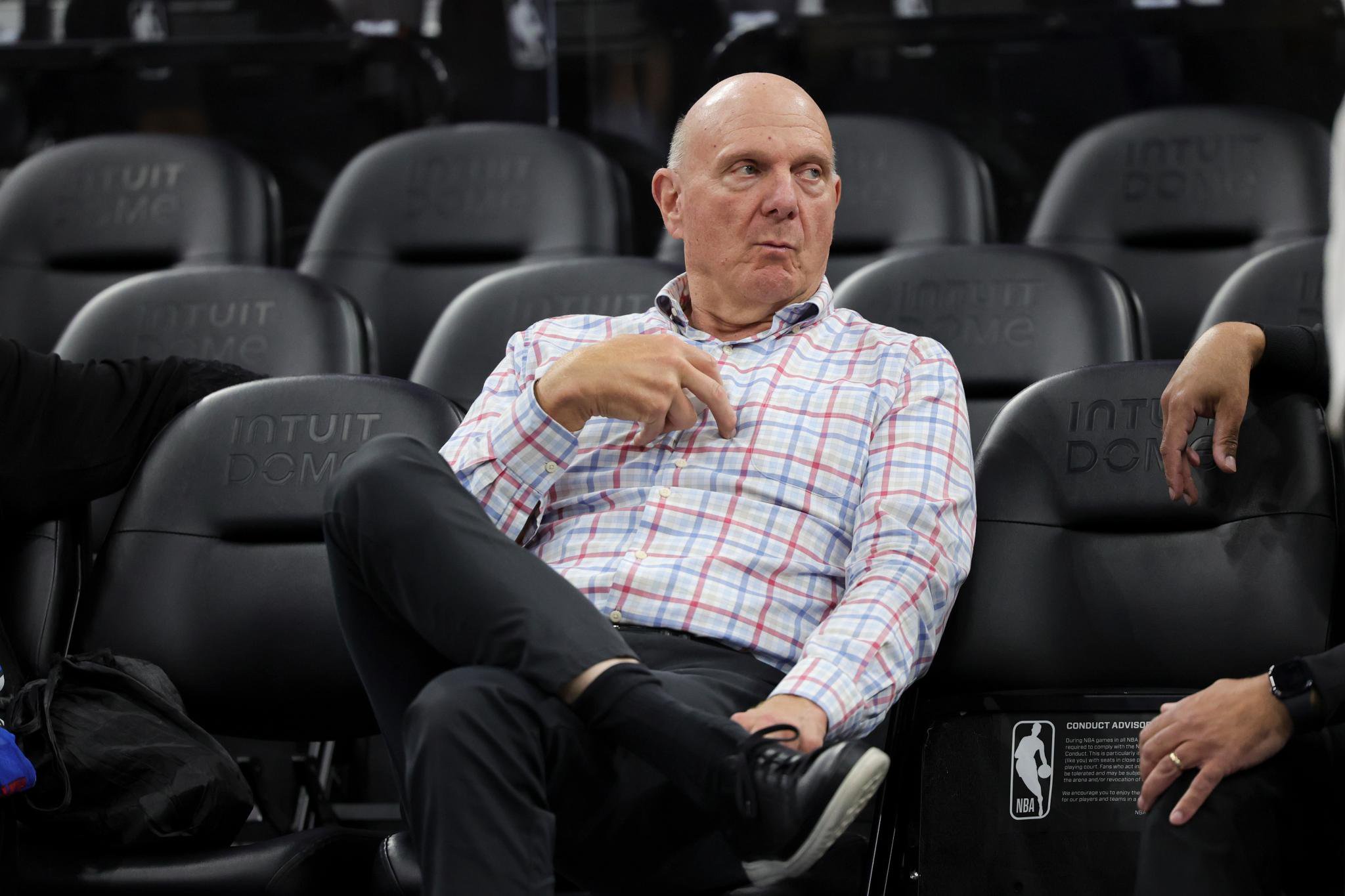 Los Angeles Clippers owner Steve Ballmer sits on the sideline before an NBA basketball game.
