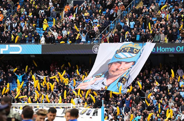 Manchester City fans with a tifo and inflatable bananas in the stands (Martin Rickett/PA)