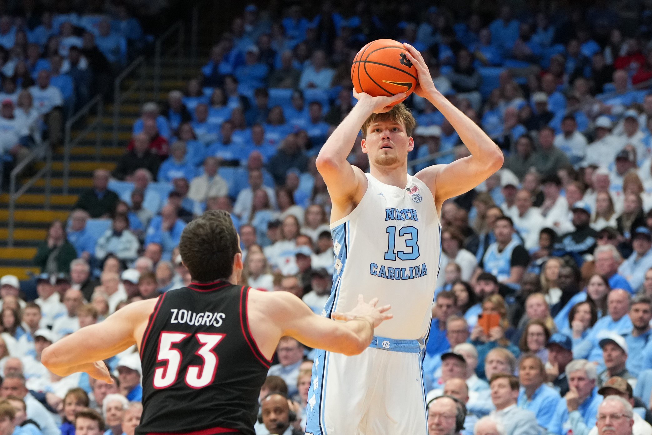 Feb 23, 2026; Chapel Hill, North Carolina, USA; North Carolina Tar Heels center Henri Veesaar (13) shoots a three point shot as Louisville Cardinals forward Vangelis Zougris (53) defends in the second half at Dean E. Smith Center. Mandatory Credit: Bob Donnan-Imagn Images