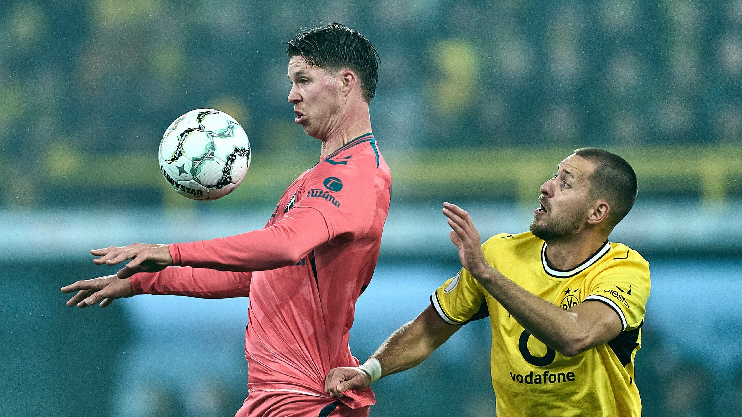 Werders Itten nimmt den Ball mit der Brust an. Dortmunds Anton befindet sich hinter ihm.