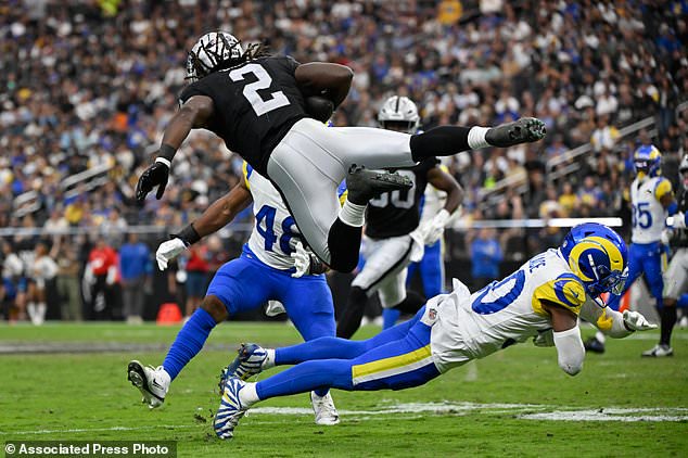 Las Vegas Raiders running back Ashton Jeanty (2) is tripped up by Los Angeles Rams cornerback Josh Wallace during the second half of an NFL football game Sunday, Oct. 25, 2026, in Las Vegas. (AP Photo/David Becker)