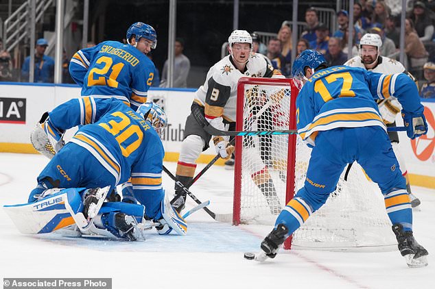 Vegas Golden Knights' Jack Eichel (9) watches as the puck slides in front of the net past St. Louis Blues goaltender Joel Hofer (30), Jimmy Snuggerud (21) and Cam Fowler (17) during the first period of an NHL hockey game Thursday, Oct. 22, 2026, in St. Louis. (AP Photo/Jeff Roberson)