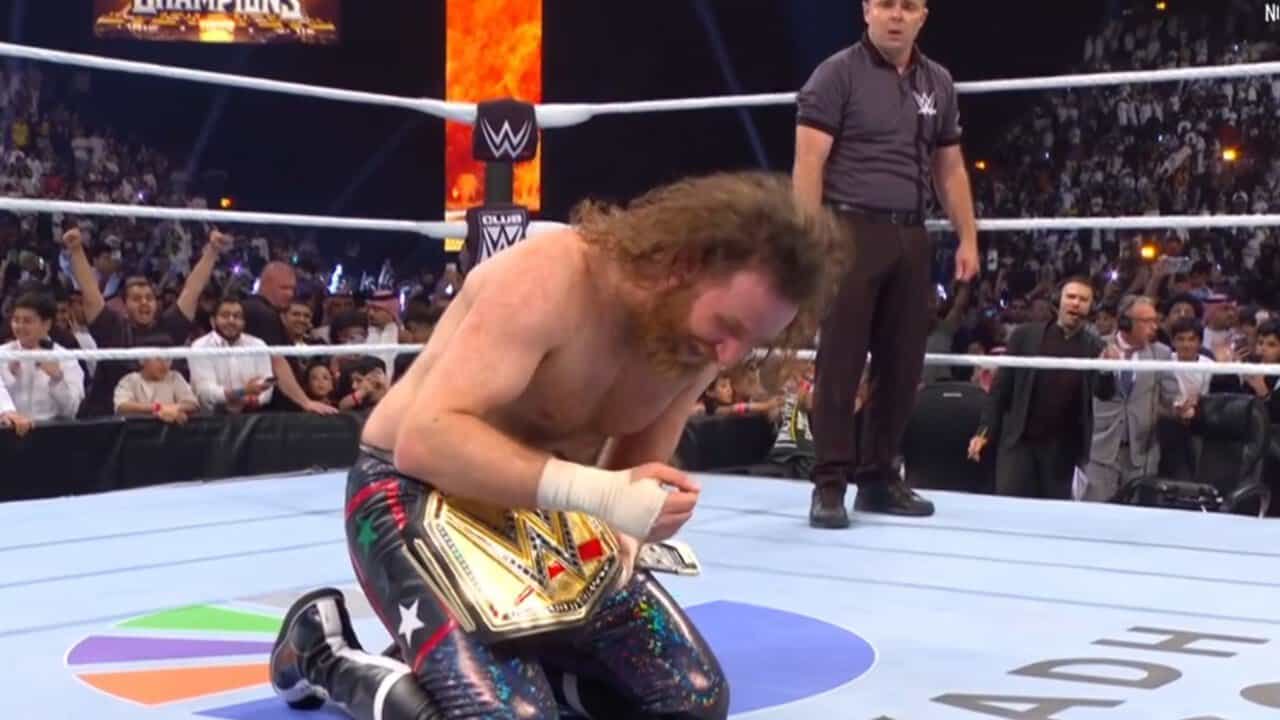 Sami Zayn kneels with the Undisputed WWE Championship after winning it at Night of Champions 2026 in Riyadh