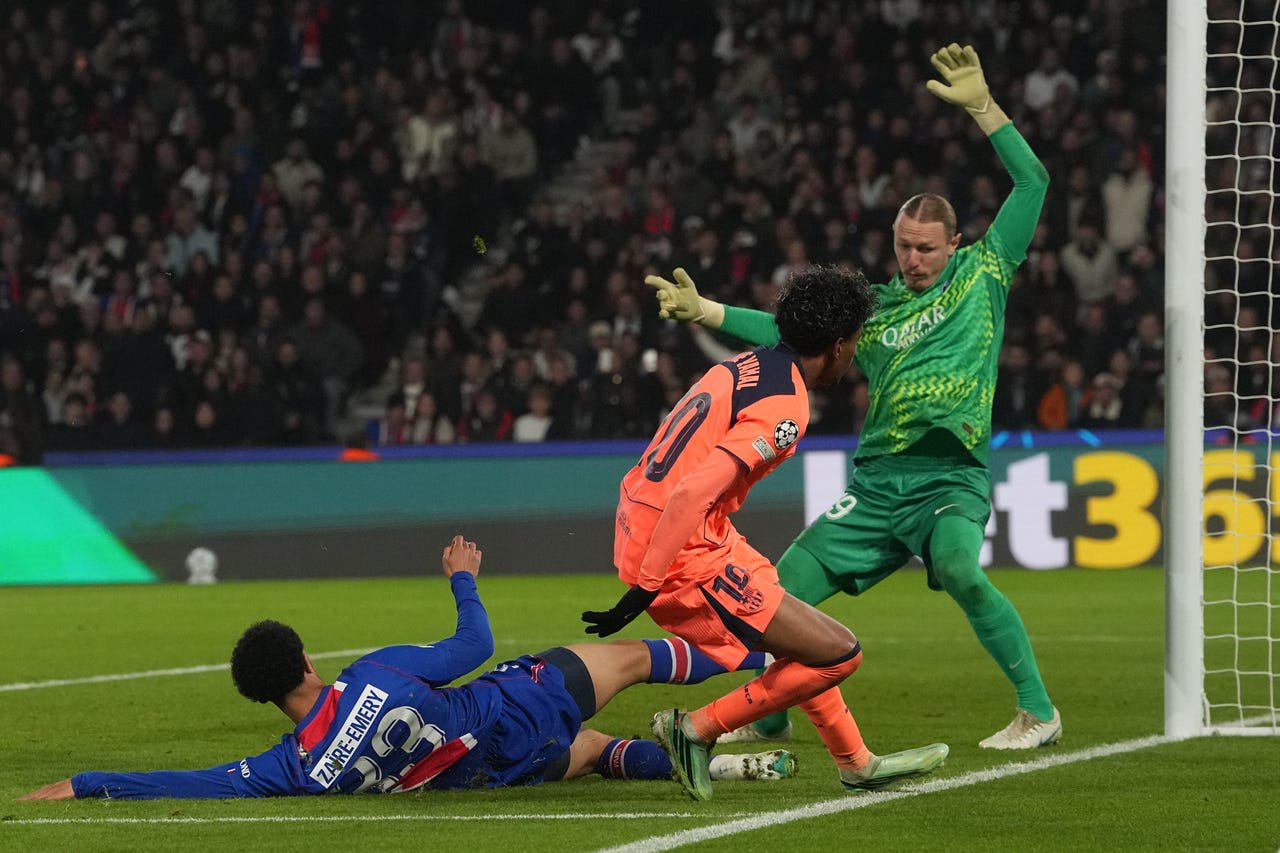 Barcelona’s Lamine Yamal, centre, scores his side’s second goal past PSG keeper Matvey Safonov, right