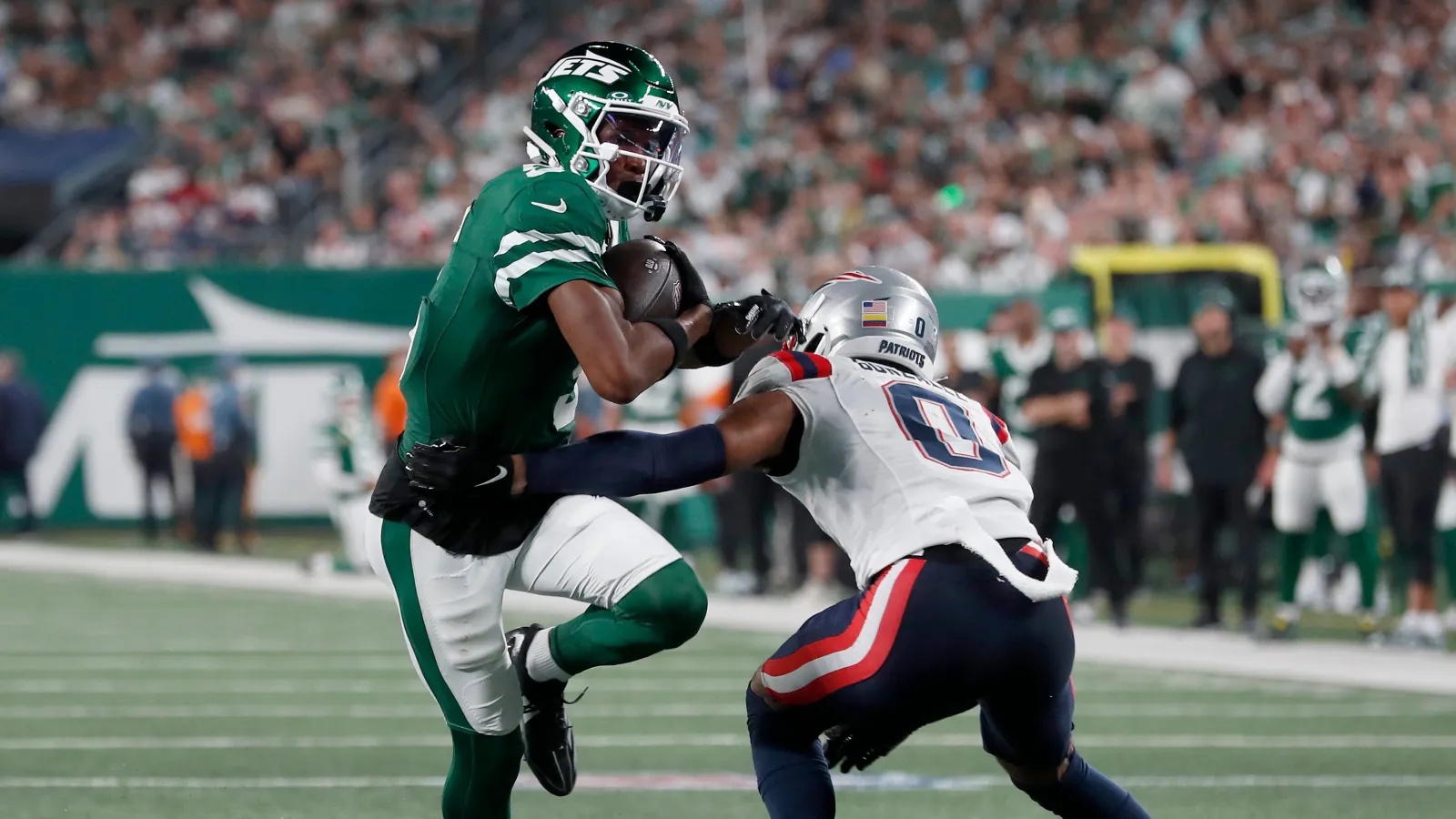 Garrett Wilson #5 of the New York Jets in action against Christian Gonzalez #0 of the New England Patriots