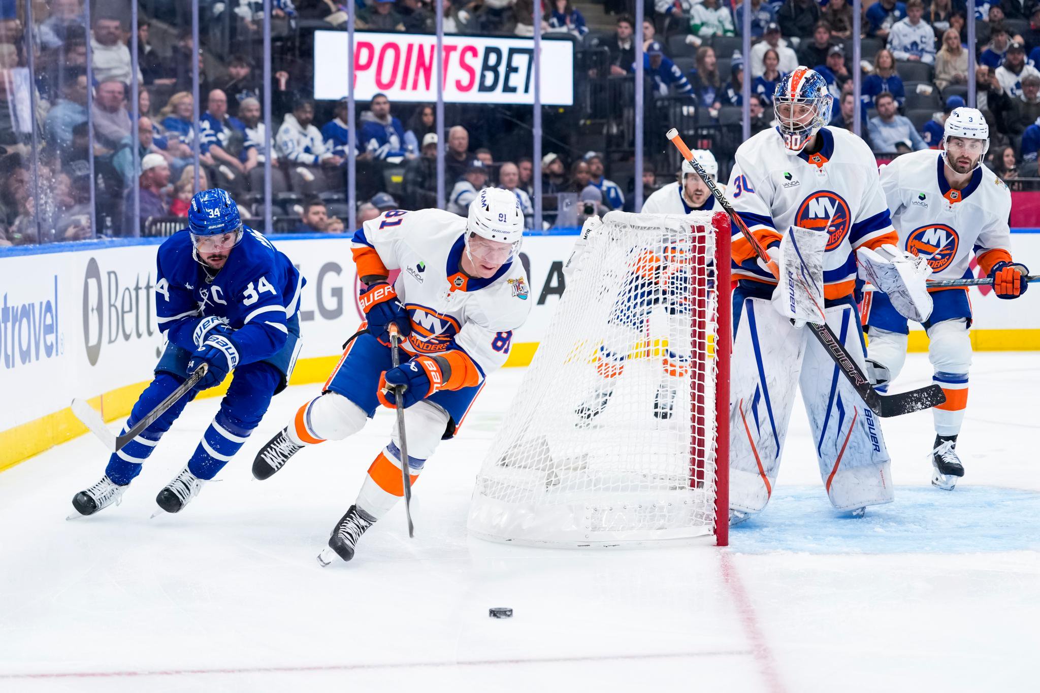 Ondrej Palat #81 of the New York Islanders handles the puck against Auston Matthews #34 of the Toronto Maple Leafs during an NHL game.