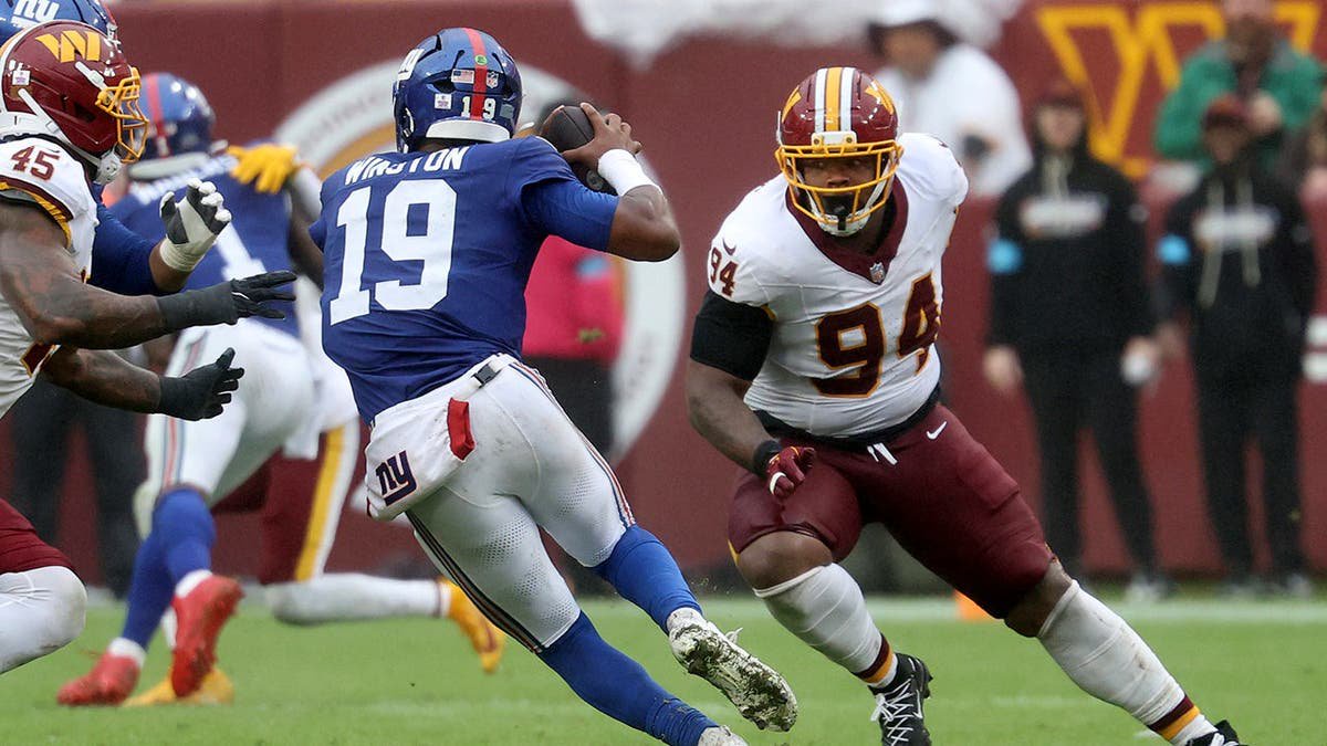 Daron Payne chases Jameis Winston during an NFL game at Northwest Stadium.
