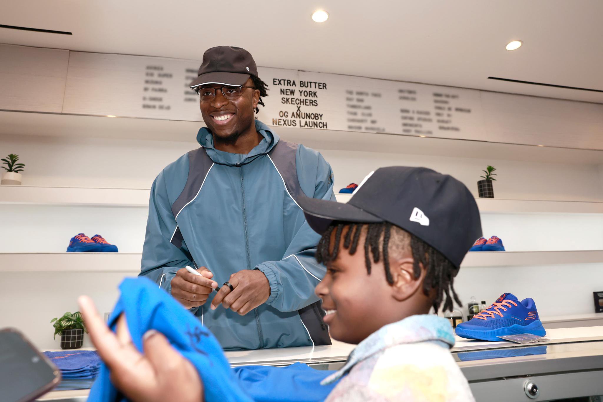 OG Anunoby signing a t-shirt for a young fan at the Skechers x OG Anunoby Nexus launch at Extra Butter.