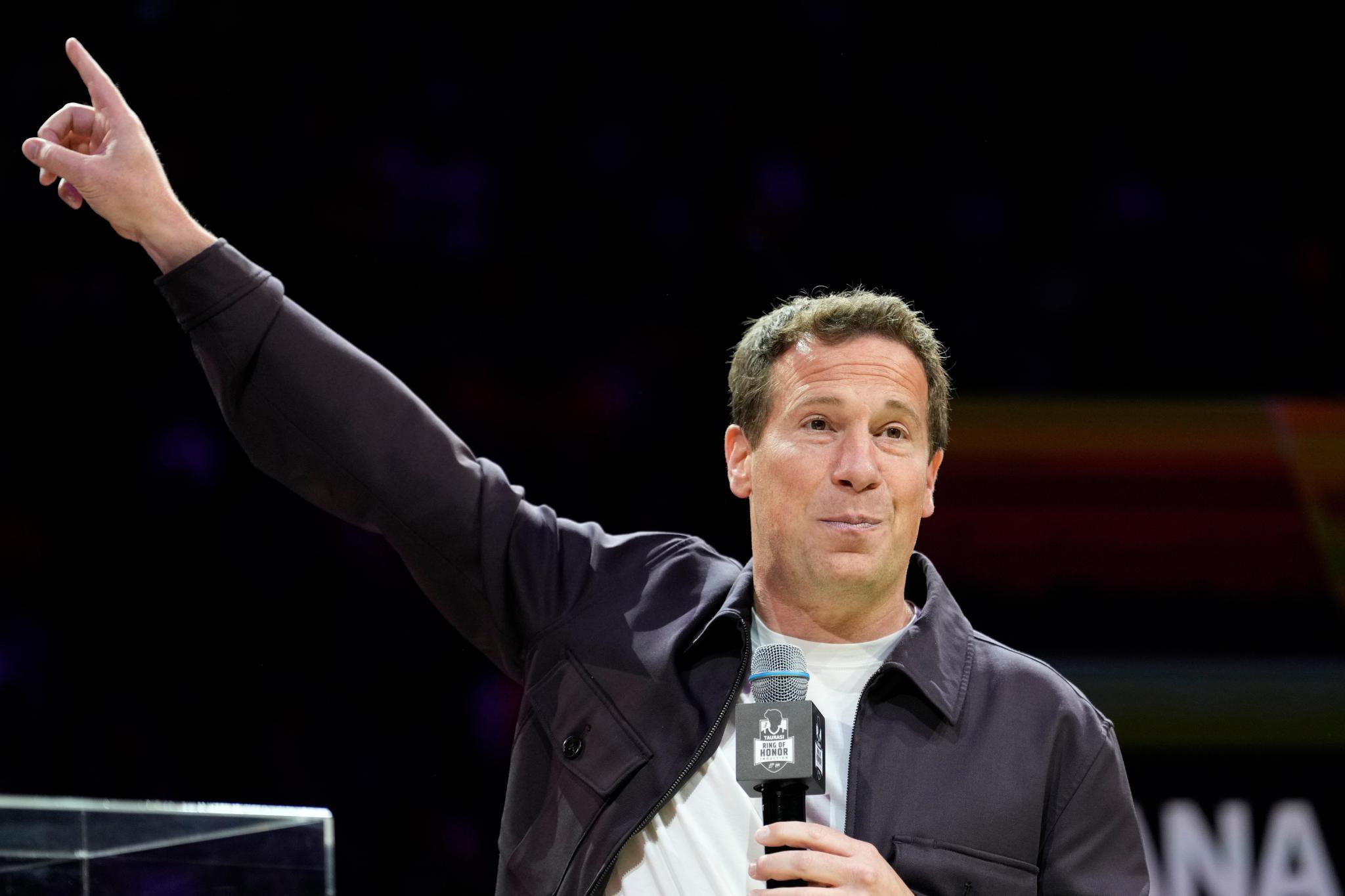 Phoenix Mercury and Phoenix Suns owner Mat Ishbia speaks into a microphone with his arm raised during a ceremony in Phoenix.