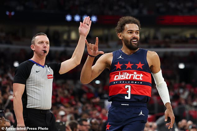 Washington Wizards guard Trae Young (3) gestures as the referee, left, gestures after making a three point basket during the first quarter of an NBA basketball game against the Chicago Bulls, Saturday, Oct. 24, 2026, in Chicago. (AP Photo/Jessie Alcheh)