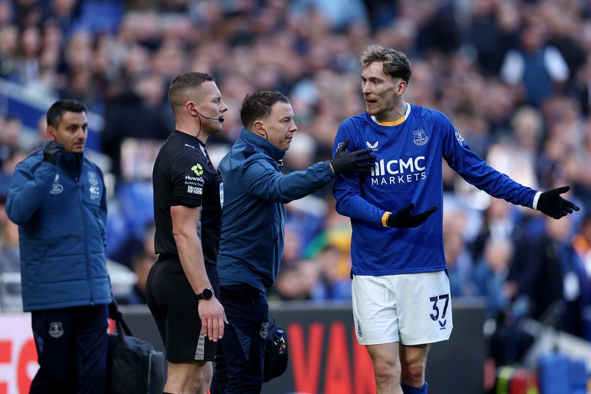 James Garner speaks with the assistant referee Wade Smith during Everton's defeat to Chelsea