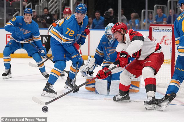 Carolina Hurricanes' Jackson Blake (53) reaches for a loose puck as St. Louis Blues' Justin Barron (72) defends during the third period of an NHL hockey game Saturday, Oct. 24, 2026, in St. Louis. (AP Photo/Jeff Roberson)