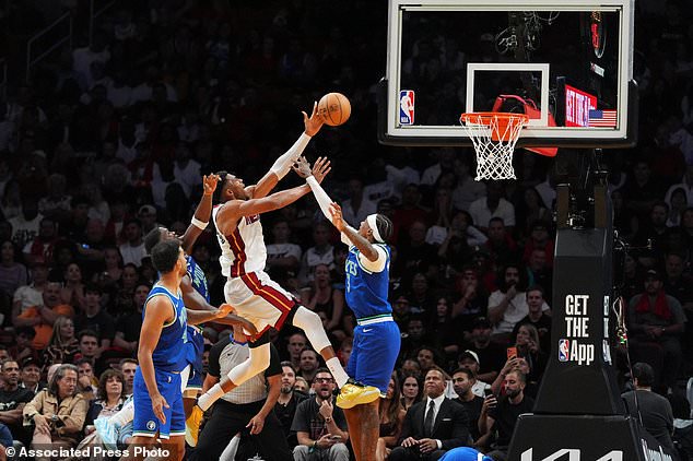 Miami Heat forward Giannis Antetokounmpo, center, goes for the basket defended by Minnesota Timberwolves forward Jaden McDaniels (3), guard Anthony Edwards (5) and forward Trey Lyles (41) during the second half of an NBA basketball game, Wednesday, Oct. 21, 2026, in Miami. (AP Photo/Rebecca Blackwell)