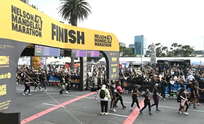Runners cross the finish line of the inaugural Nelson Mandela Marathon in Cape Town on Sunday, celebrating their achievements after taking on the streets of the Mother City.