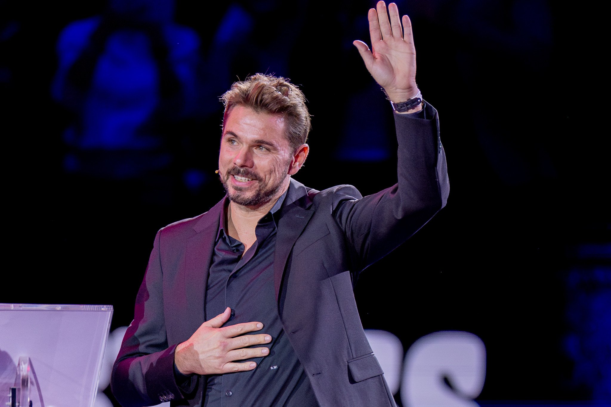 Stan Wawrinka winkt dem Publikum bei den Swiss Indoors in Basel, eine Hand auf der Brust, gekleidet in schwarzem Jackett.