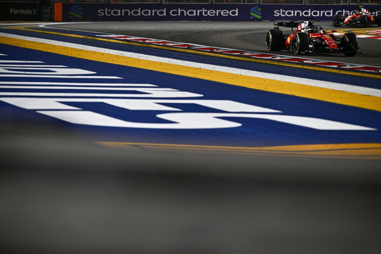 Ferrari driver Charles Leclerc leads teammate Lewis Hamilton on track during the 2026 F1 Singapore Grand Prix